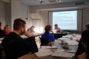 ludzie siedzą na sali konferencyjnej