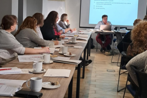 ludzie siedzą na sali konferencyjnej