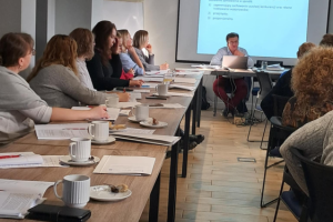 ludzie siedzą na sali konferencyjnej