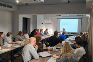 ludzie siedzą na sali konferencyjnej