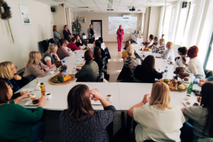 ludzie siedzą na sali konferencyjnej