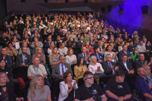 grupa ludzi siedzi na widowni