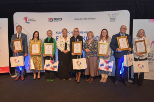 ludzie stoją w rzędzie trzymając nagrody