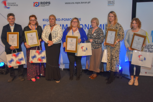 ludzie stoją w rzędzie trzymając nagrody