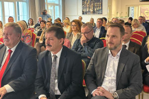 ludzie siedzą na sali konferencyjnej