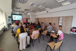 grupa ludzie siedzi w sali konferencyjnej