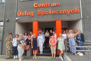 grupa ludzi pozuje przed budynkiem