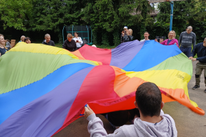 ludzie trzymają kolorową chustę