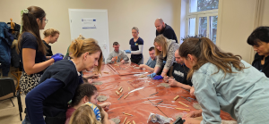 ludzie przy stole wykonują prace plastyczne