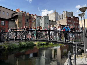 grupa ludzi stoi na moście