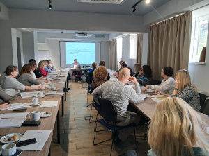 ludzie siedzą na sali konferencyjnej