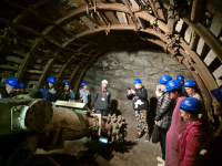 grupa ludzi w kaskach w kopalni