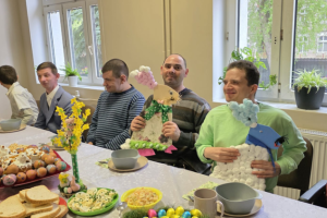 mężczyźni siedzą przy stole z ozdobami świątecznymi