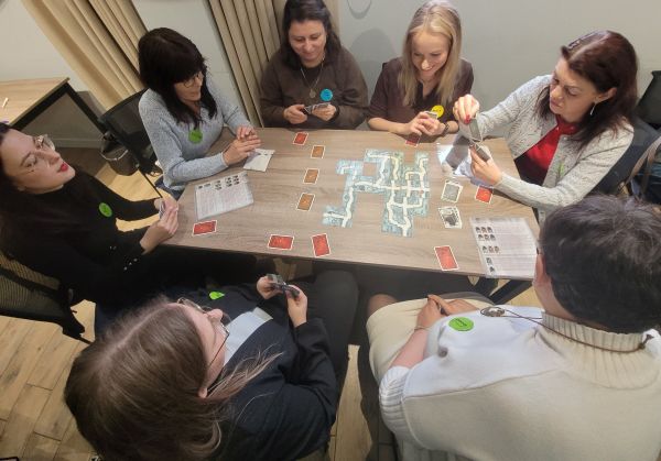 Grupa ludzi gra w grę planszową