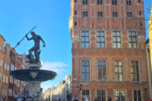 ludzie stoją przed fontanną neptuna