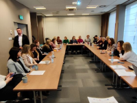 ludzie siedzą przy stole konferencyjnym