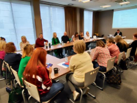 ludzie siedzą przy stole konferencyjnym