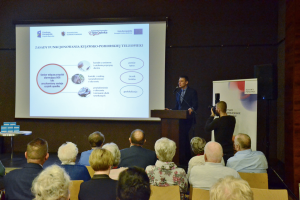 mężczyzna przemawia przed siedzącą widownią