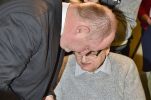 mężczyzna nachyla się nad siedzącym mężczyzną