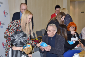 grupa ludzi wśród nich kobieta z tarczą na berecie