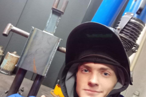 mężczyzna w stroj spawacza unosi kciuk w górę