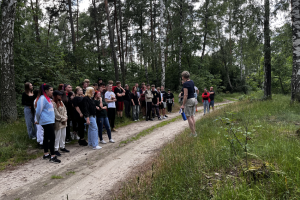 grupa ludzi stoi na leśnej ścieżce