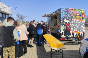 ludzie stoją w kolejce przed food truckiem