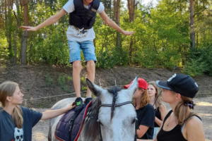 dziecko stoi na koniu