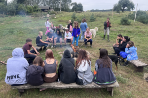 ludzie siedzą dookoła ogniska