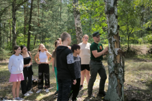 grupa ludzi stoi w lesie