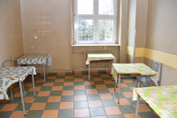 stoły stoją w zniszczonym pokoju