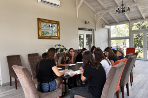 grupa młodzieży siedzi przy stole