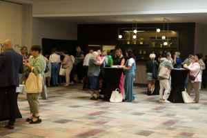 ludzie stoją przy stolikach koktajlowych