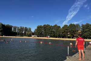 ratownik patrzy na ludzi kąpiących się w jeziorze