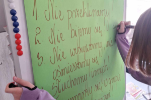 dziewczyna zapisuje hasła na tablicy