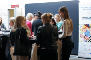 ludzie stoją przy stoliku koktajlowym